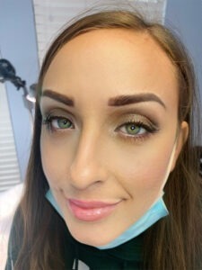 A woman wearing a blue mask and a green eyeliner.