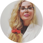unnamed-1 - Elmira Studio A woman in a white coat with a red bow in her hair.