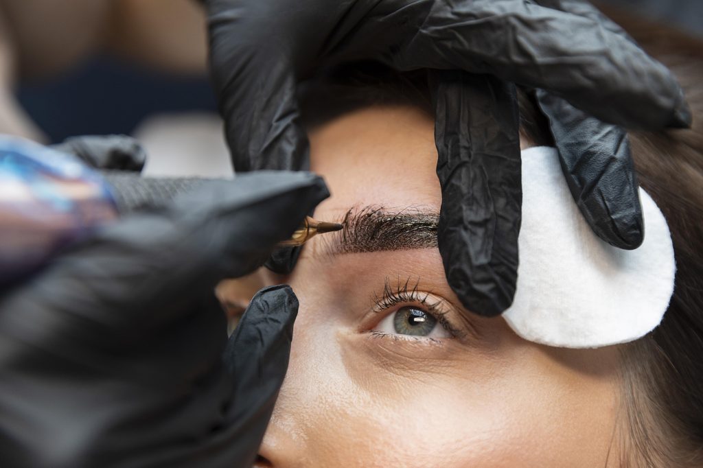 A woman getting her eyebrows tattooed.